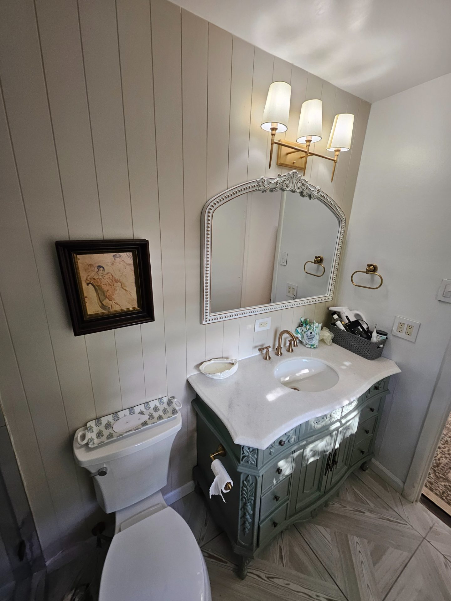 Bathroom with a double vanity, framed art and a shiplap wall
