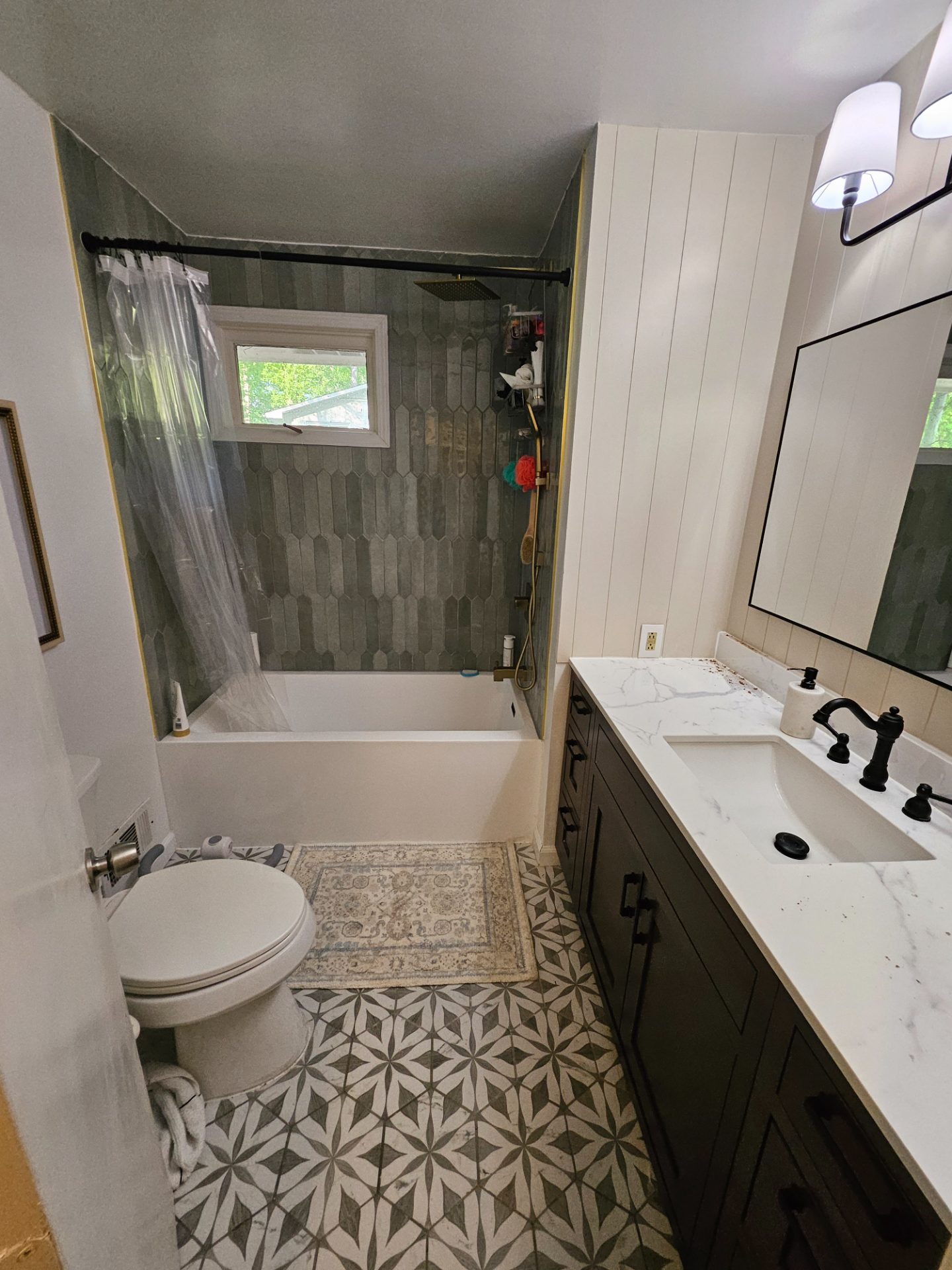 Bathroom with a tiled tub surround, vanity and large mirror