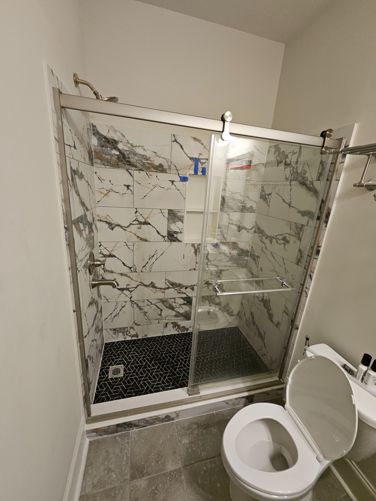 Marble shower wall with a gold rain head