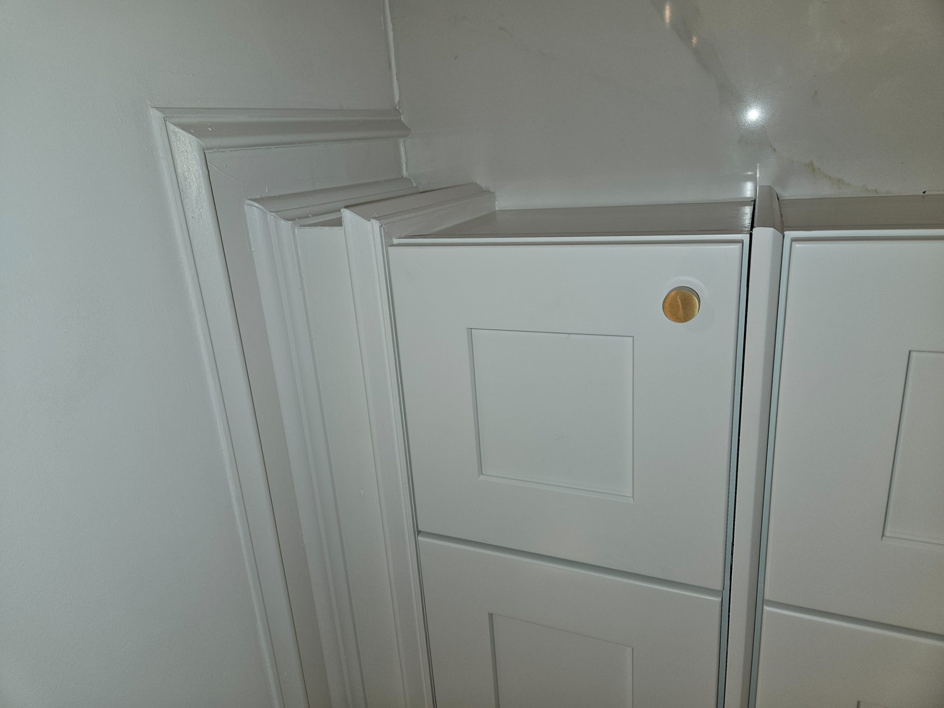 Built-up casing and crown returning into a run of white shaker cabinet doors