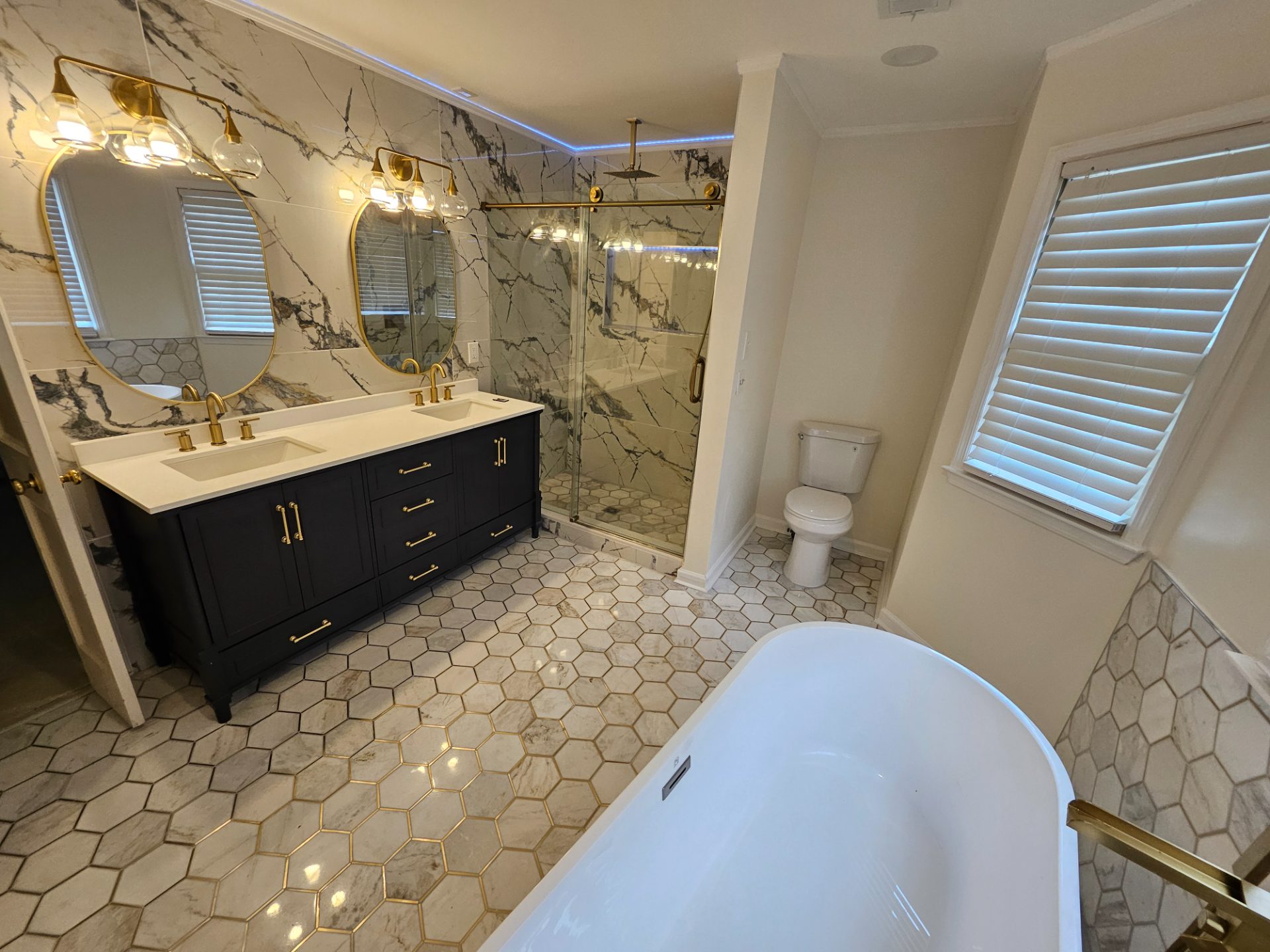 Bathroom with a green vanity, freestanding tub and hex-tile floor in Johns Creek