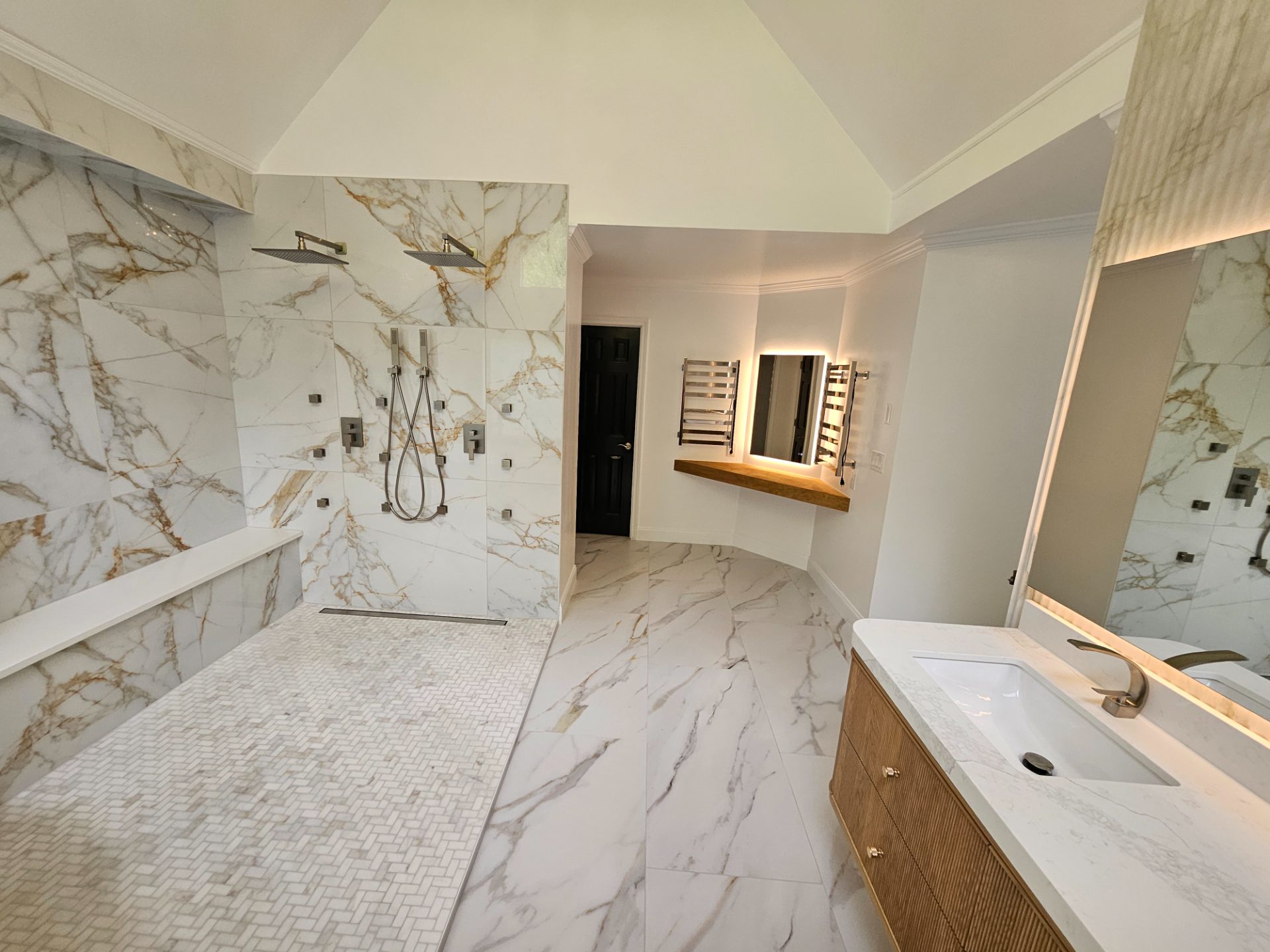 Marble bathroom with a freestanding tub under a vaulted ceiling