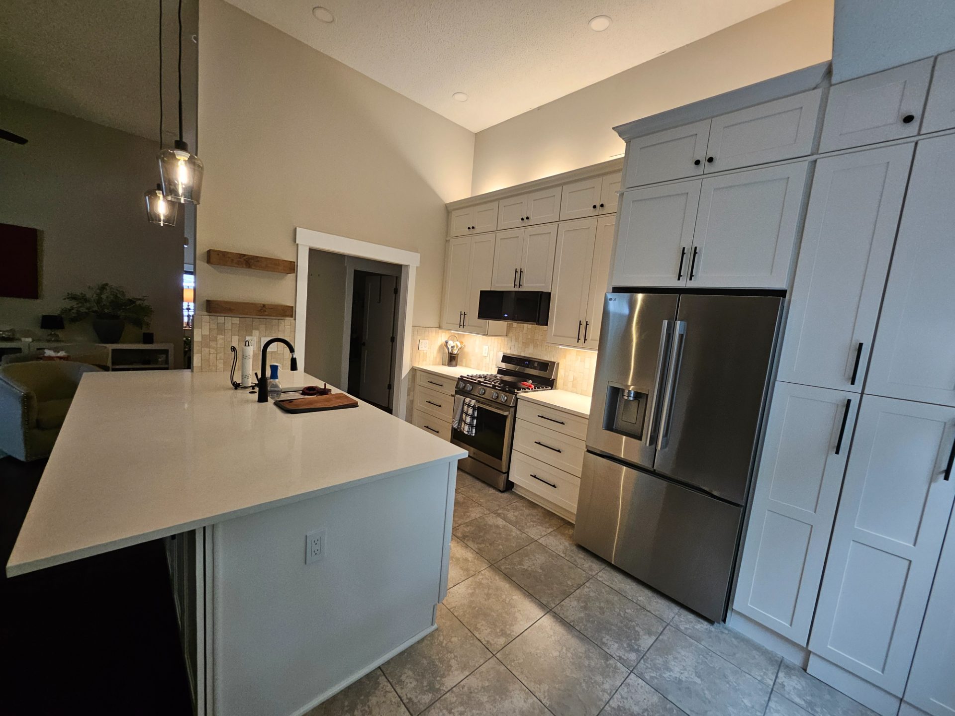 Kitchen with shiplap walls, a vaulted ceiling and a stone island in Waleska