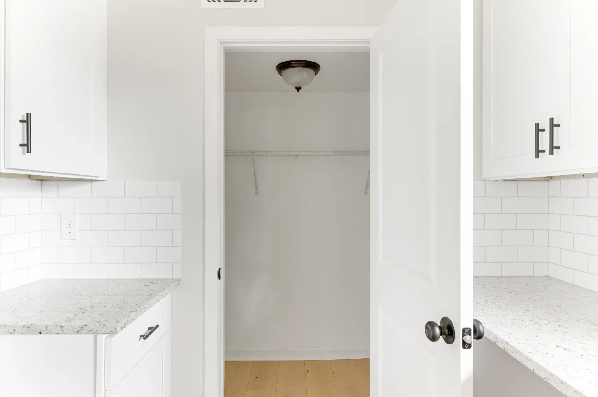 Finished white kitchen looking through to a hallway