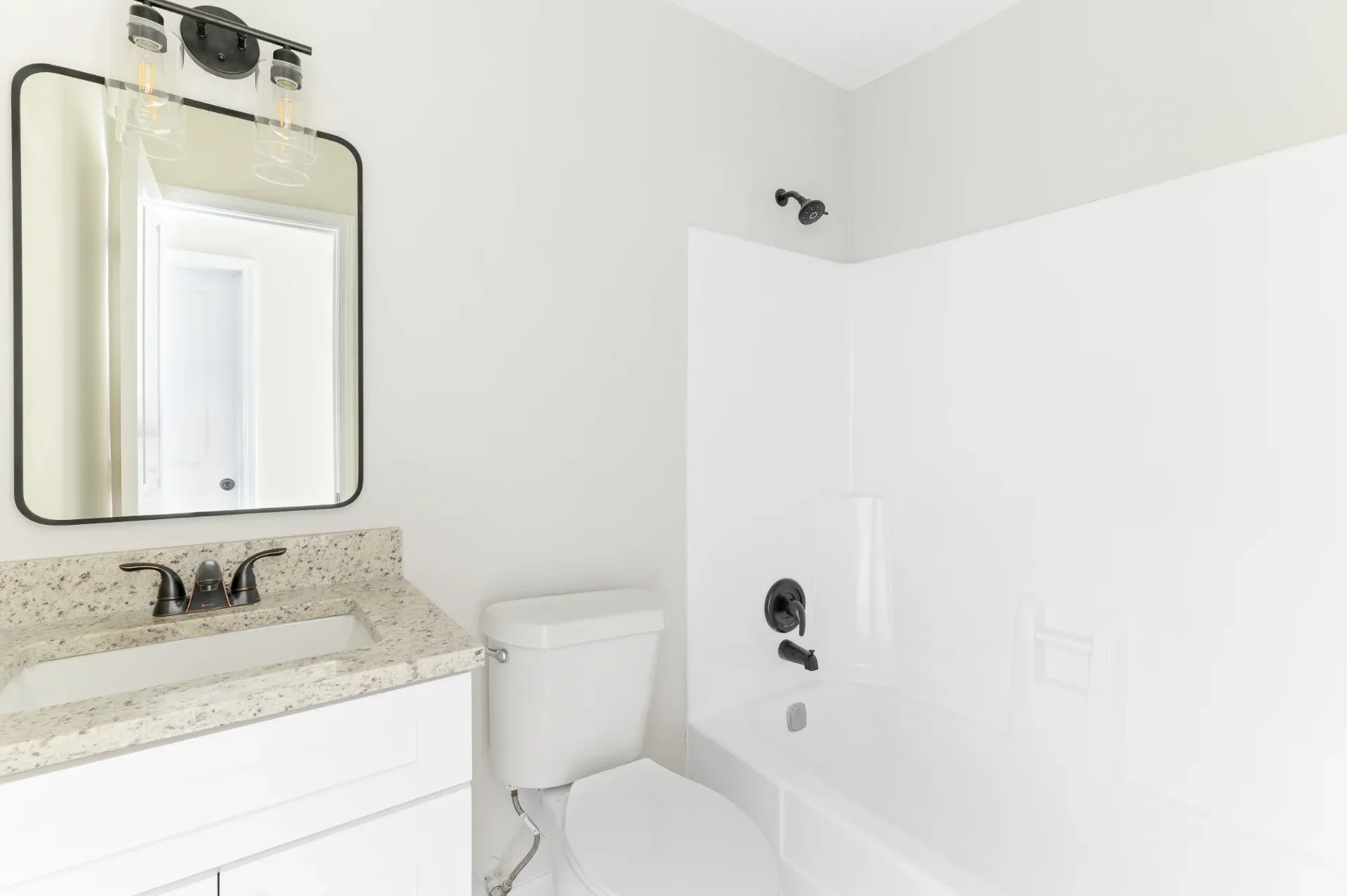 White tub and shower surround with a black shower head