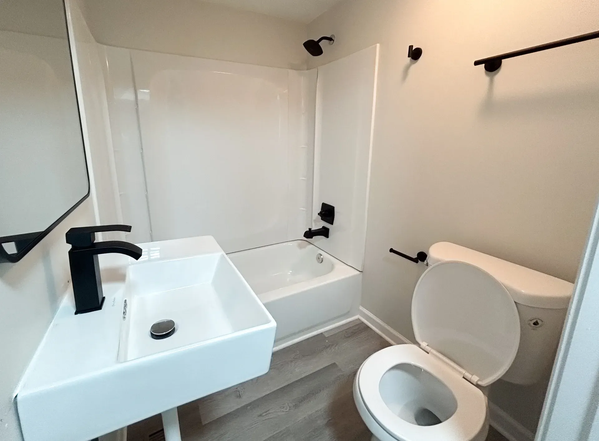 White vessel sink with a black faucet beside a toilet
