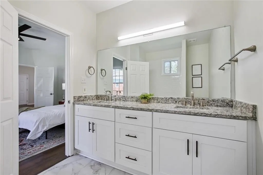 Bathroom vanity with a granite top under a framed mirror