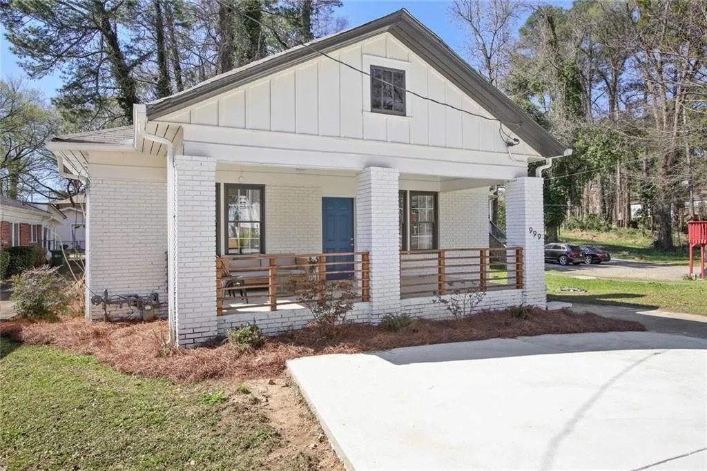 White bungalow with a covered porch and a blue front door