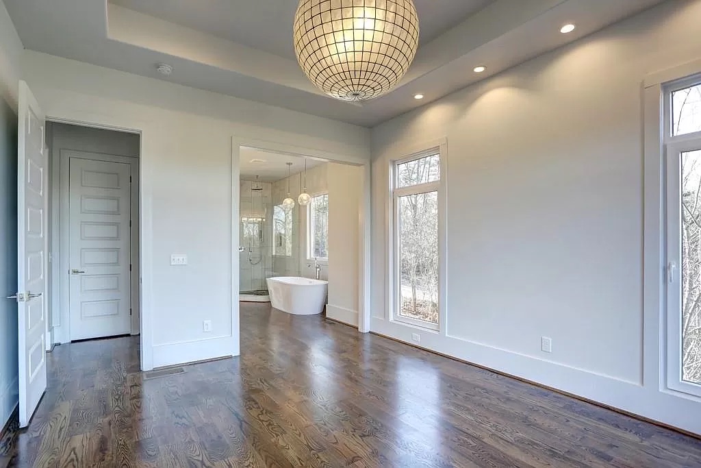 Open great room with hardwood flooring and tall windows