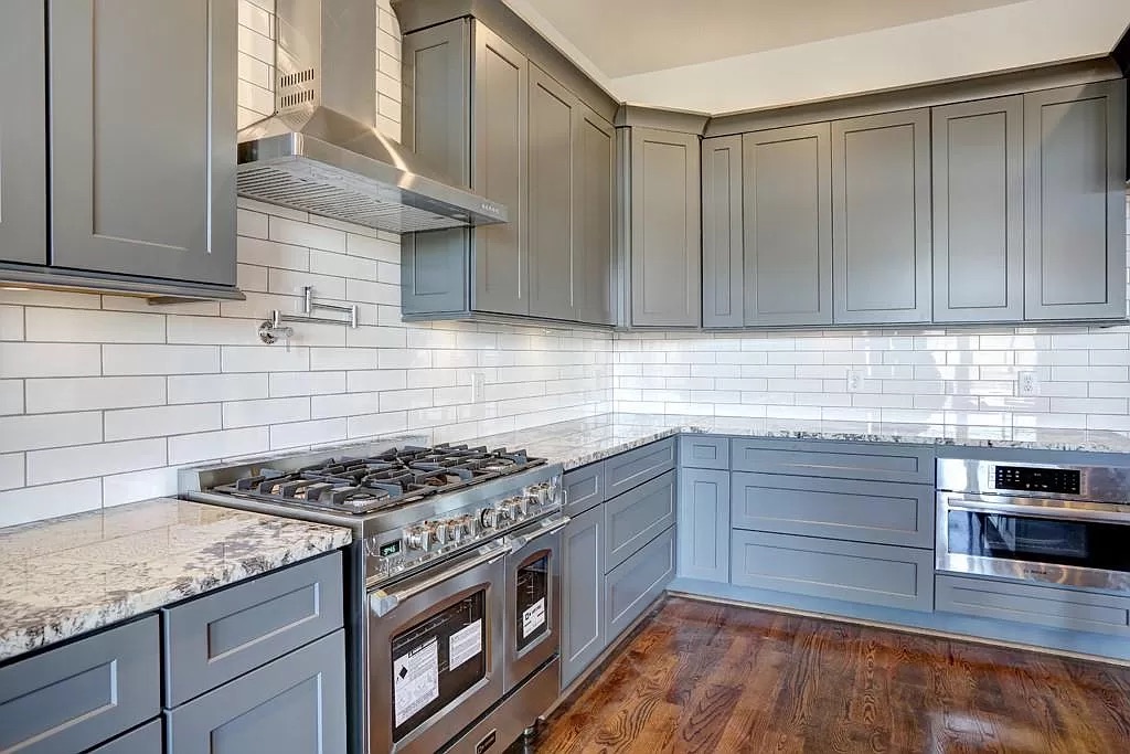 Open great room with hardwood flooring and tall windows