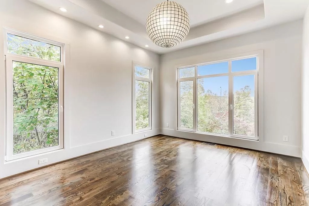 Open great room with hardwood flooring and tall windows
