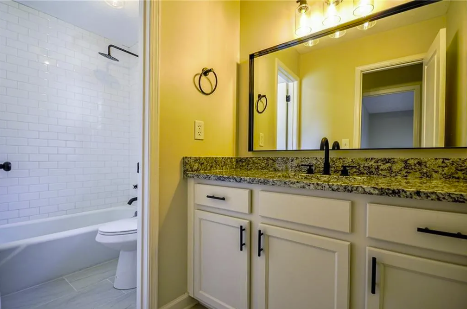 Bathroom vanity with a granite top and a framed mirror