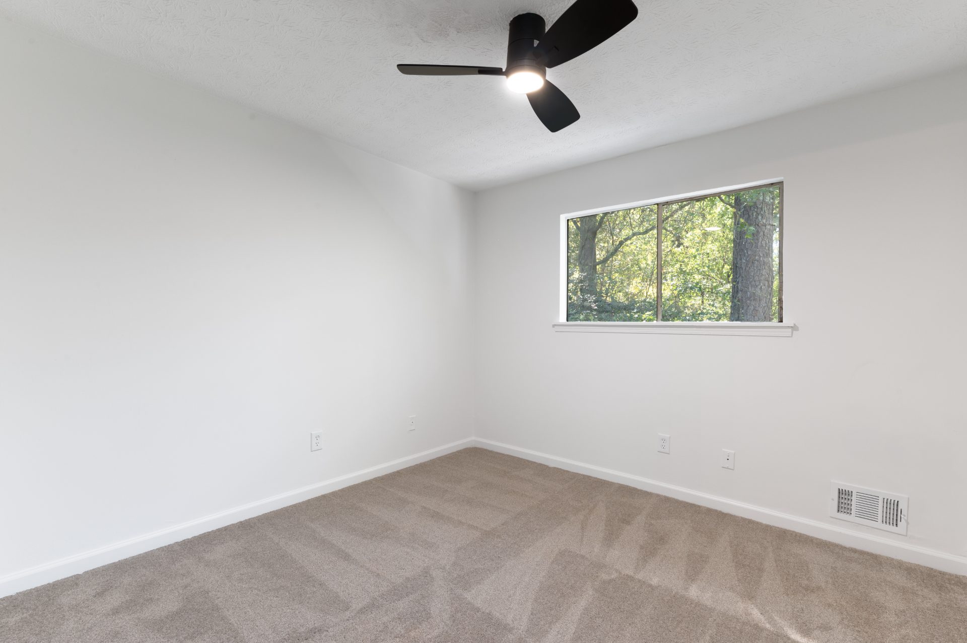 Finished bedroom with new flooring and a ceiling fan in Big Creek