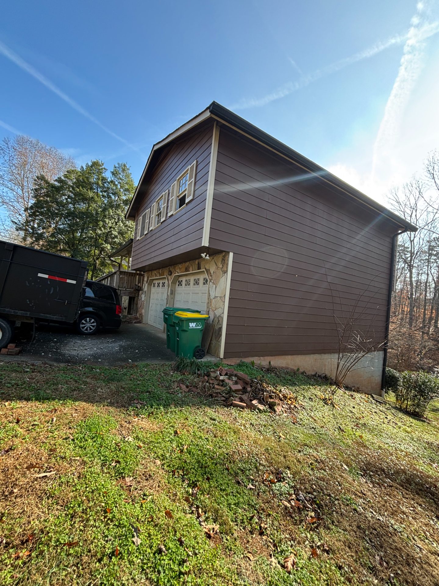 Wood-sided house on a steep wooded lot