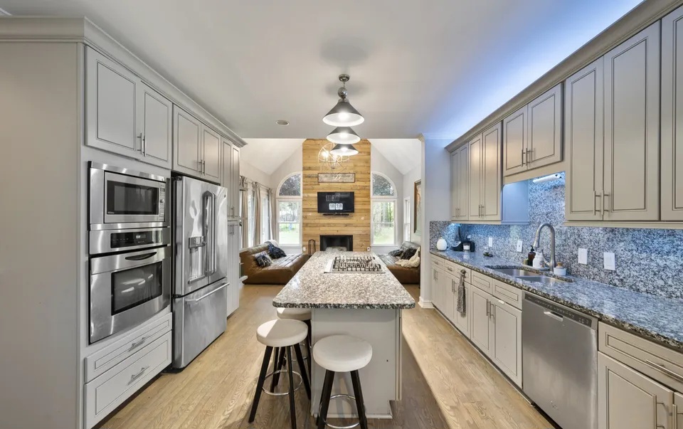 Galley kitchen with white cabinets and stainless appliances in Tucker