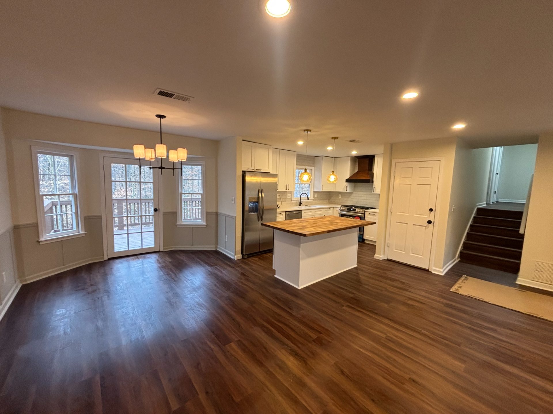 Renovated kitchen with a butcher-block island and white cabinets