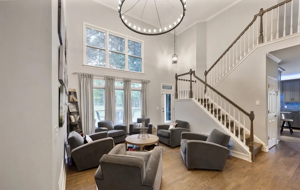Vaulted family room with a stone fireplace and a staircase