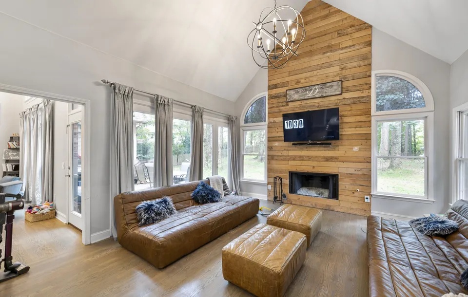 Vaulted family room with a stone fireplace and a staircase in Doraville