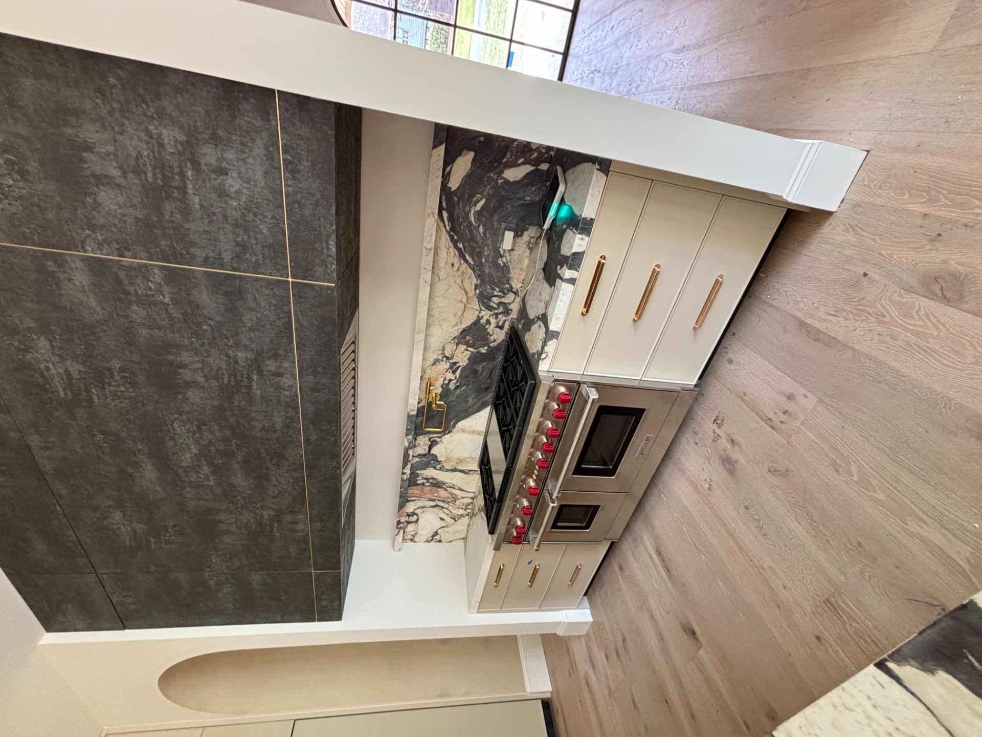 Kitchen with a full slab backsplash, wood cabinets and a pro range