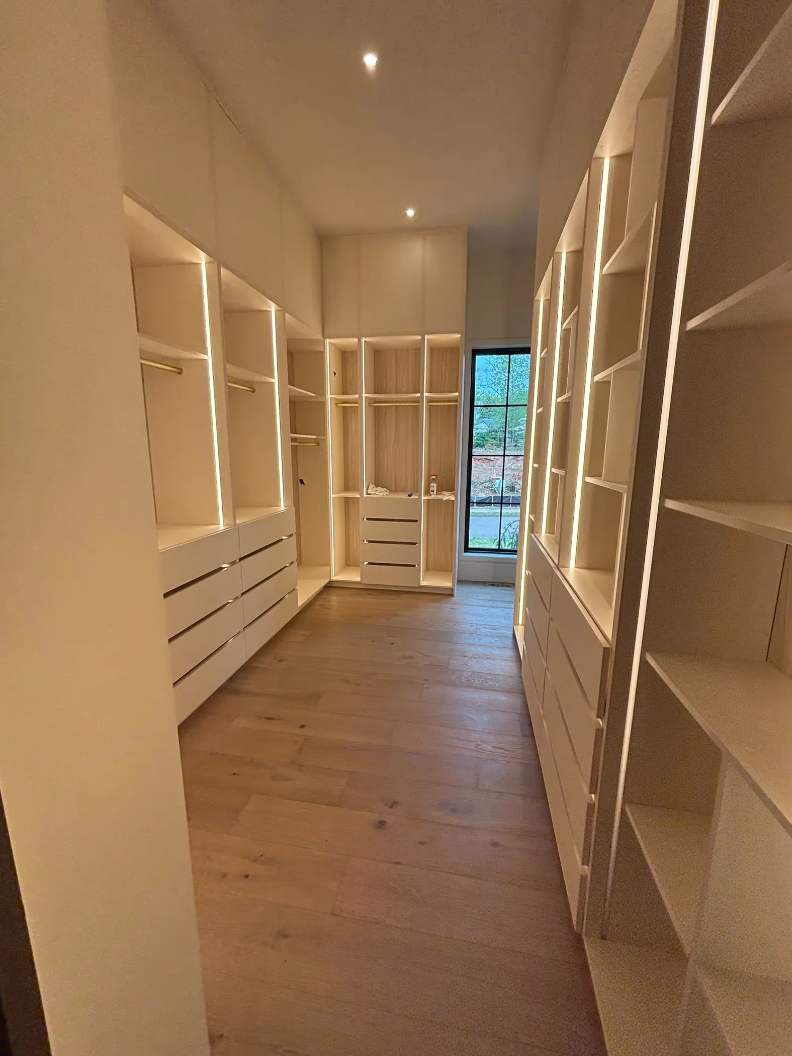 Walk-in closet built out with shelving and hanging rods