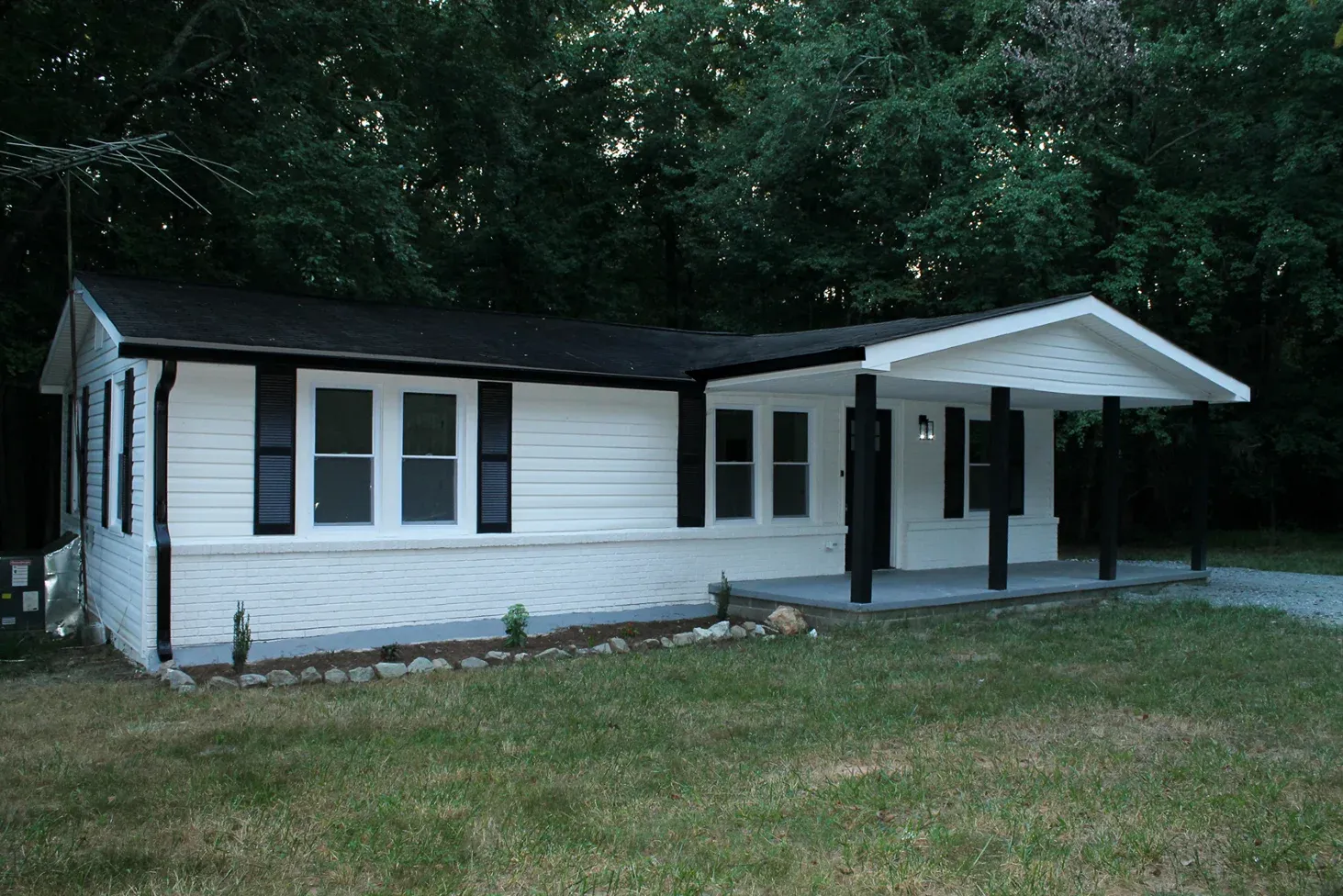 Long single-story house with dark trim and a covered entry