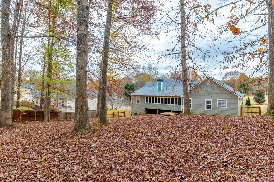 Small house among tall pines with a gravel approach