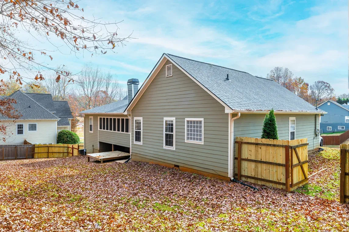 Sided house with a fenced side yard and a rear addition in Vinings