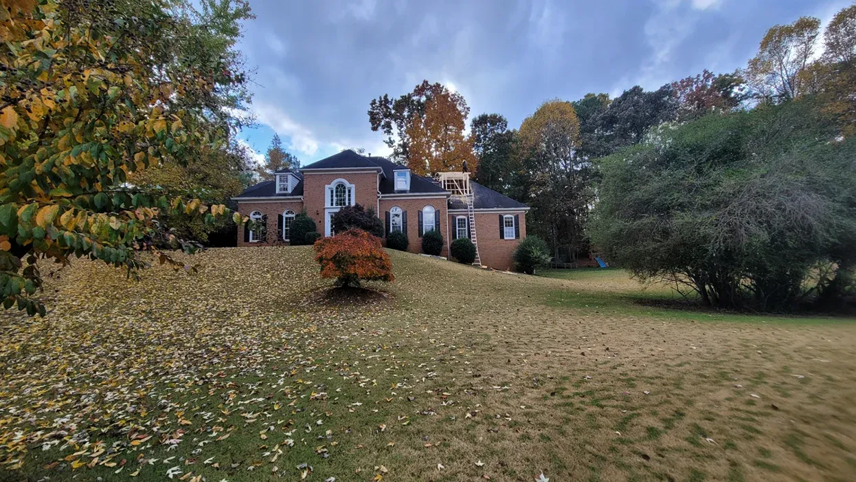 Brick two-story house with a symmetrical facade and mature landscaping in Norcross