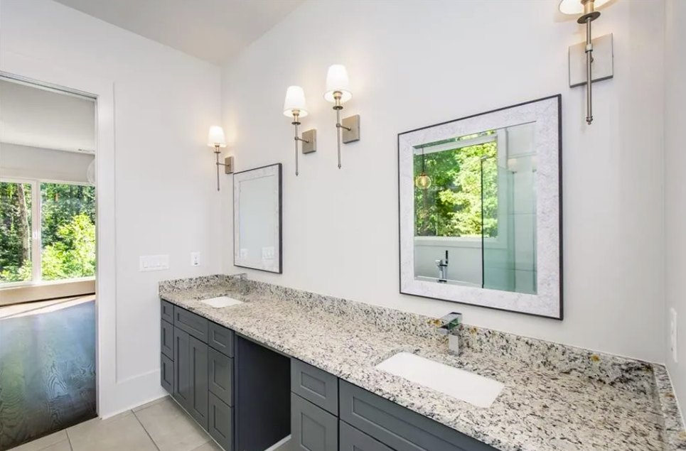 New bathroom with a long stone vanity and a glass shower