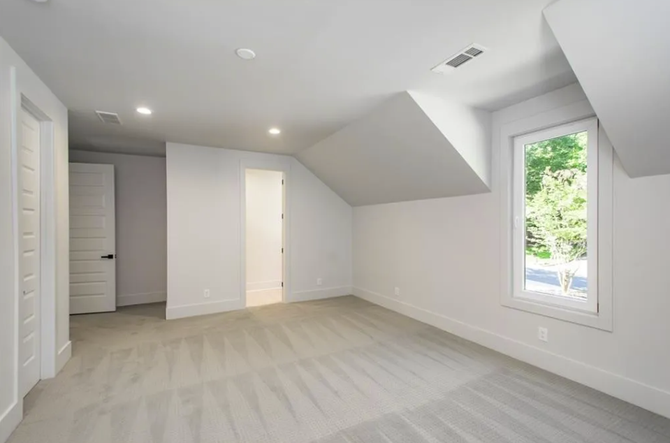 New bedroom with hardwood flooring and tall windows