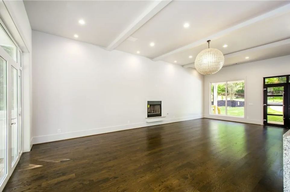 Great room with exposed beams and a wall of windows