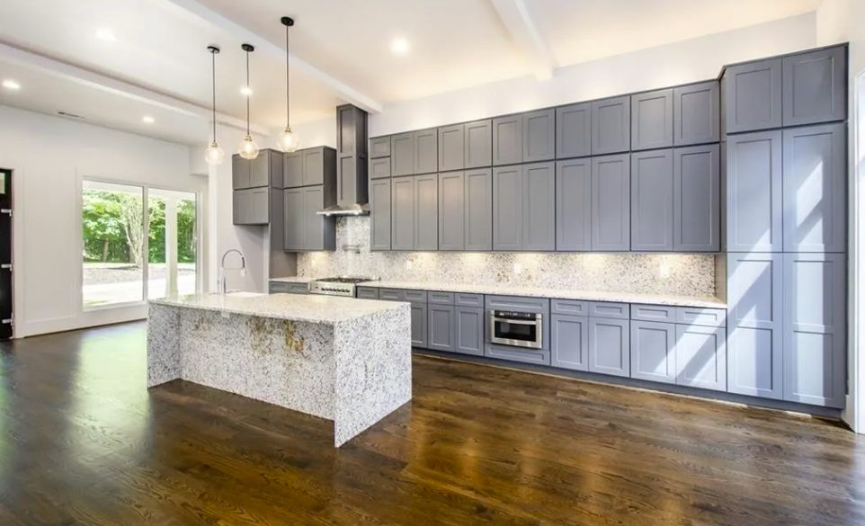 New kitchen with a stone island, gray cabinets and pendant lighting in Smyrna