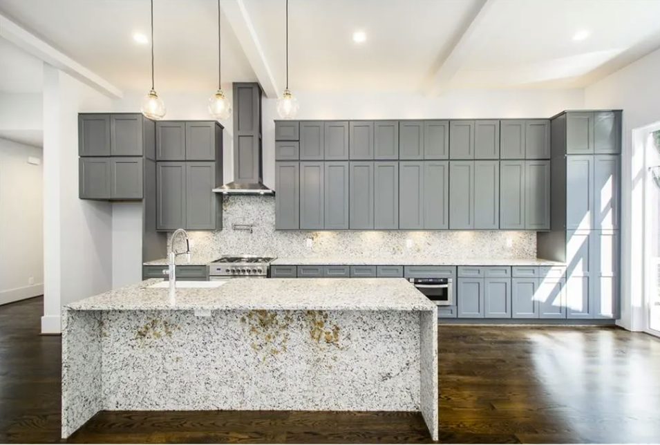 New kitchen with a stone island, gray cabinets and pendant lighting in East Cobb