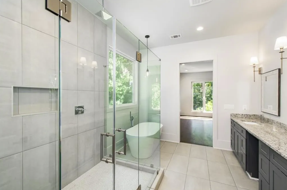 Frameless glass shower beside a freestanding tub