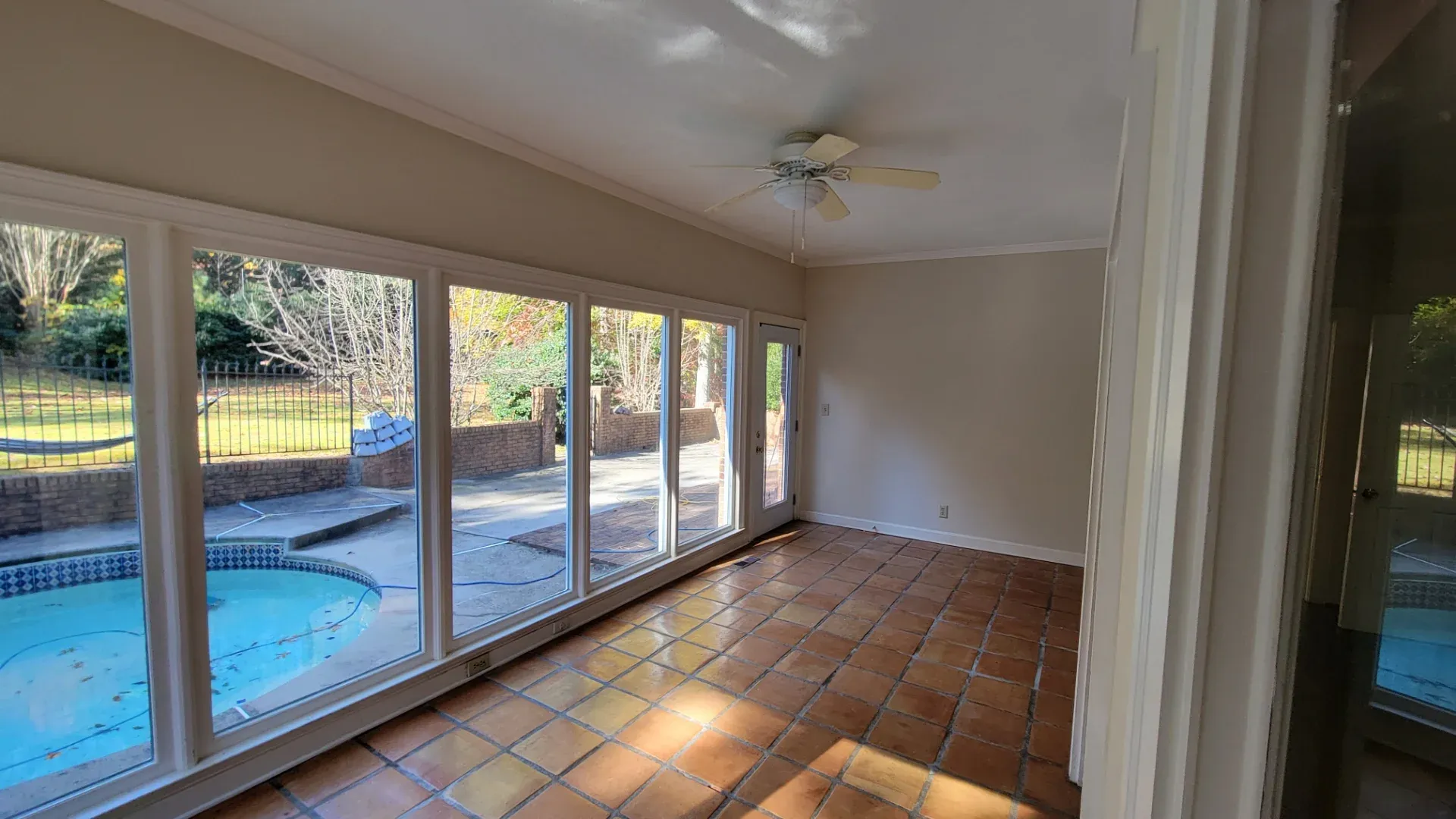 Enclosed sunroom with tile flooring looking out to a pool in Tucker