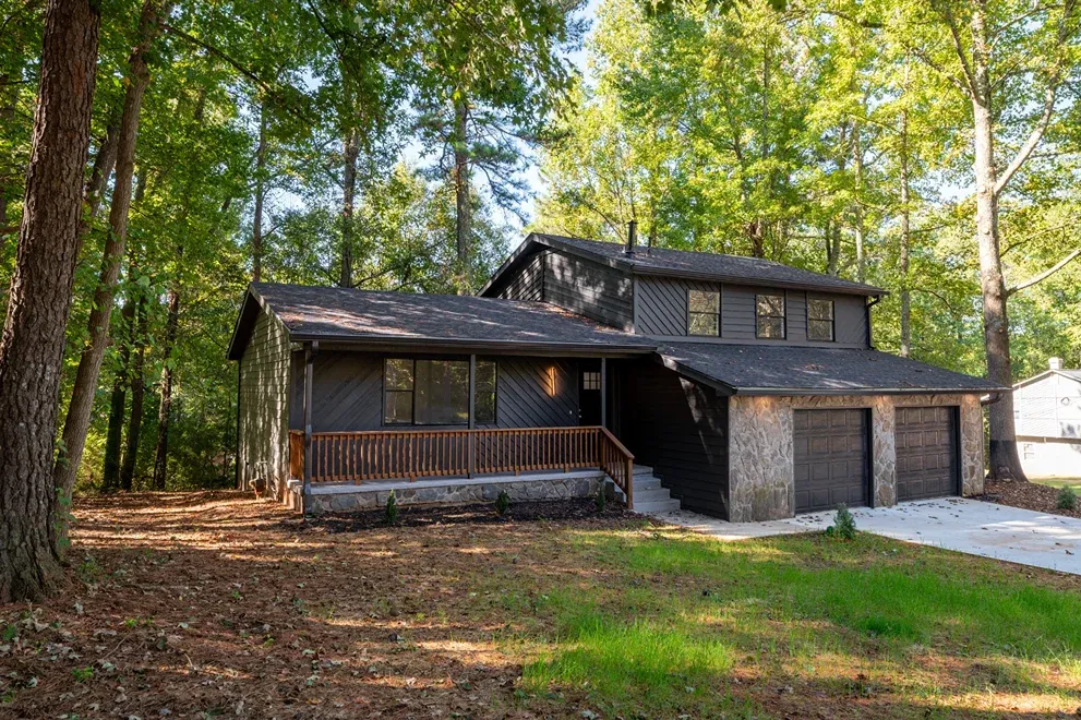 Dark-stained house with a covered porch and stone base