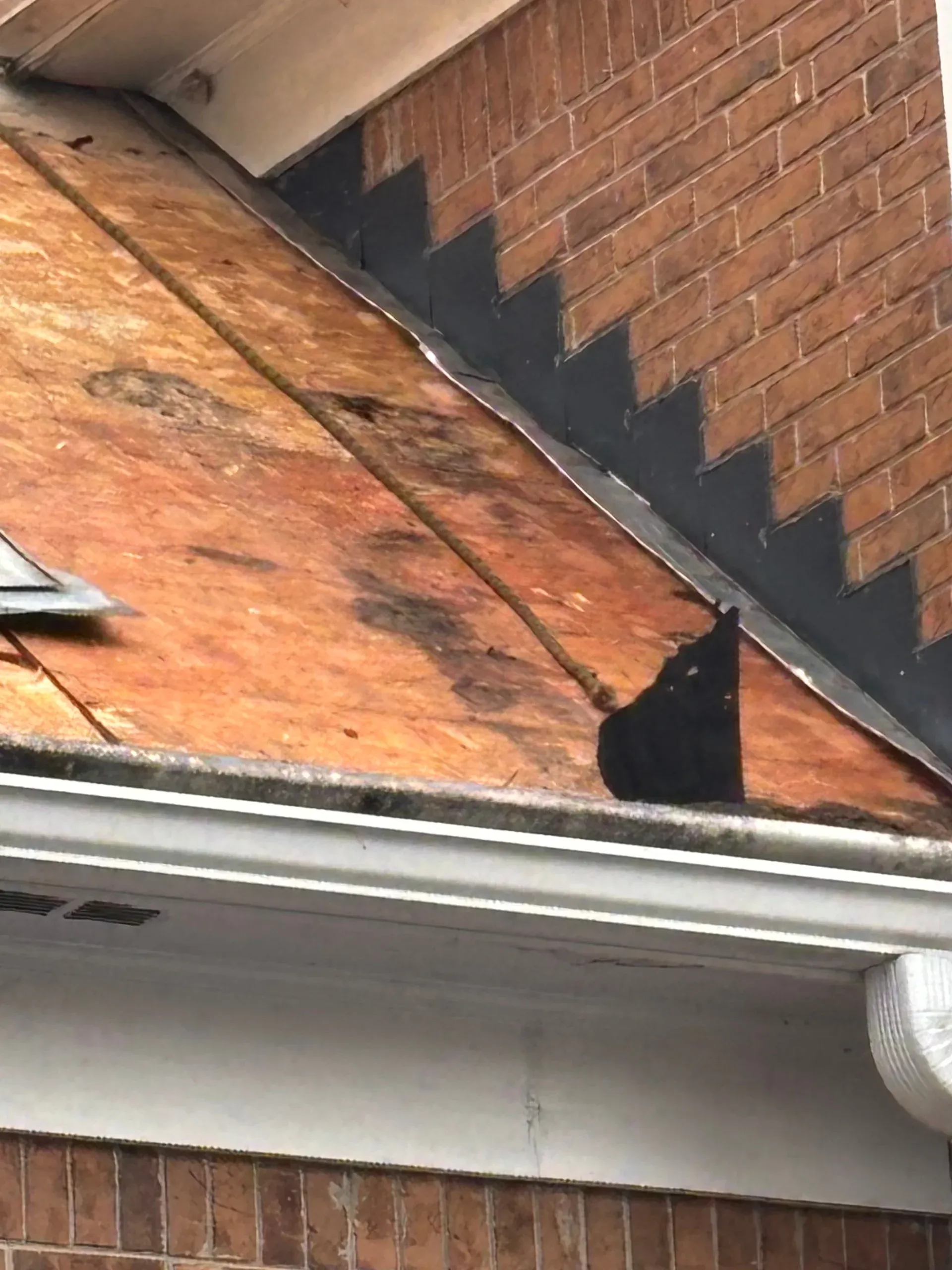 Valley and decking exposed against a brick gable