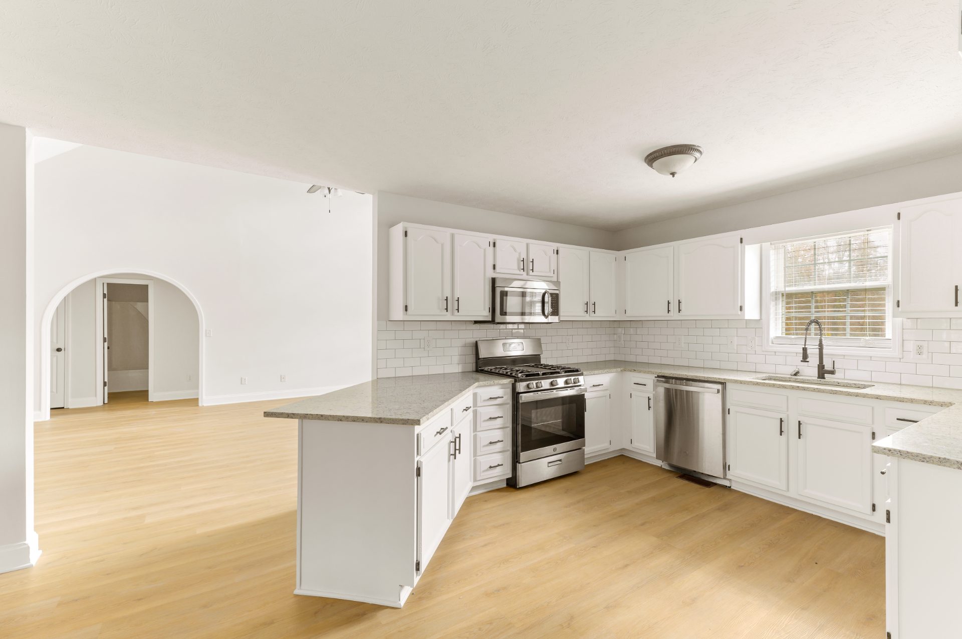 Renovated living space with a stone fireplace and an open staircase in Peachtree Corners