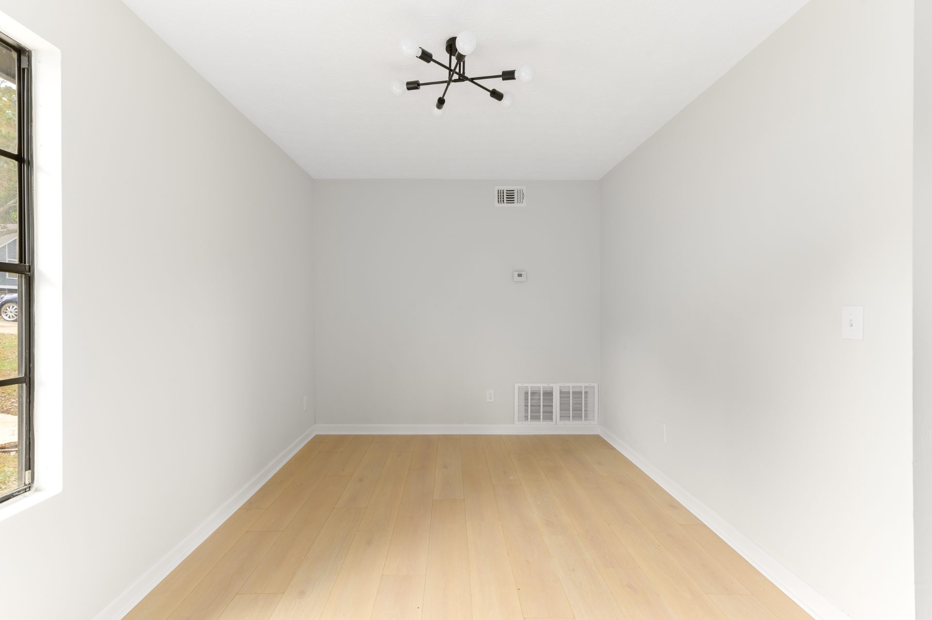 Renovated living space with a stone fireplace and an open staircase